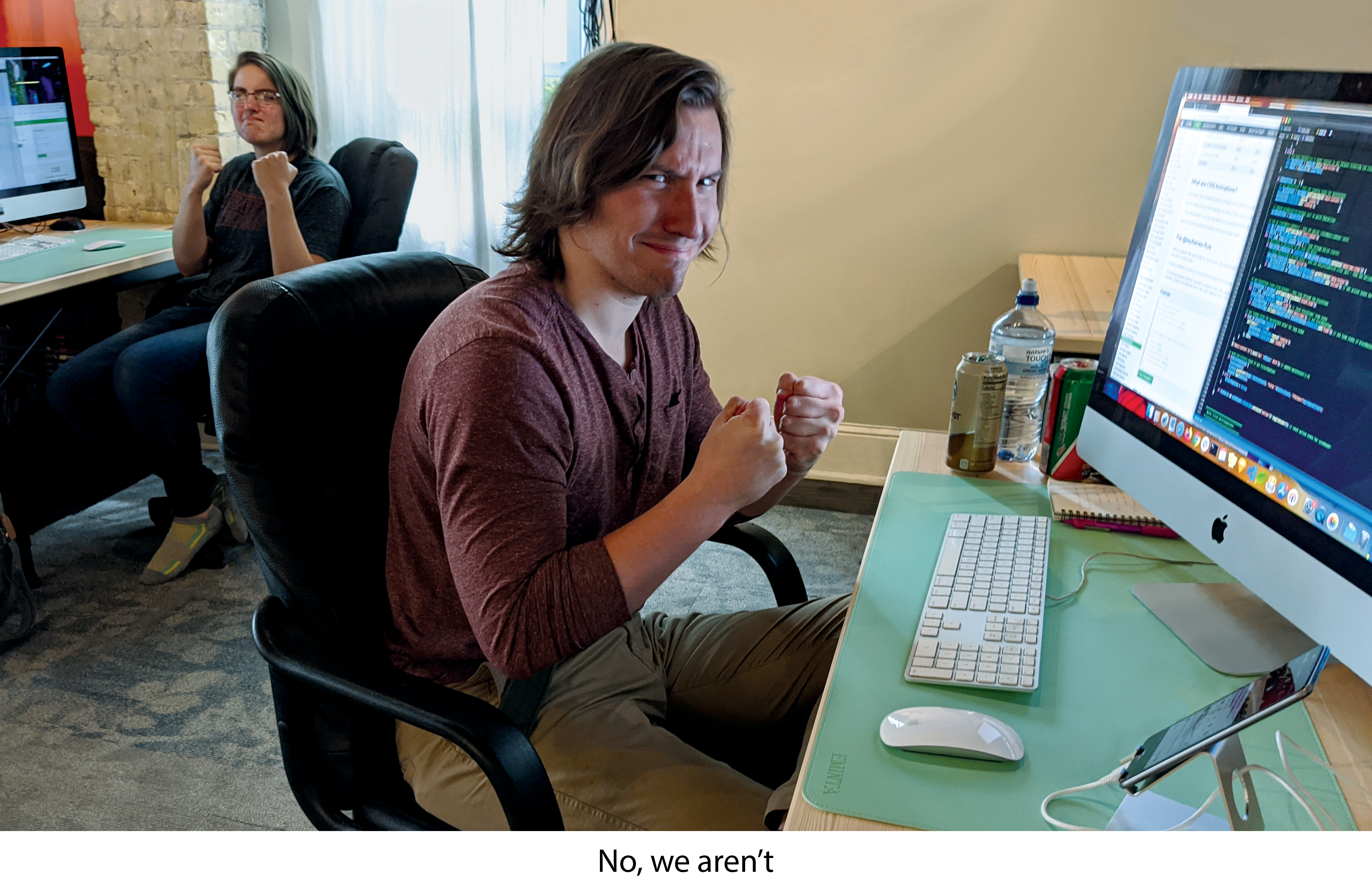 image of programmers glowing at the camera with fists, and a caption that says, "No, we aren't"