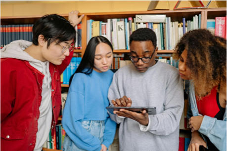 image of young adults gathered around tablet device